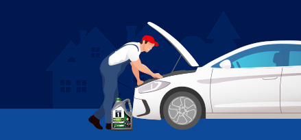 Una persona con il cofano di un'auto sollevato e una bottiglia di Mobil 1 accanto