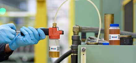 Un tecnico di Mobil preleva un campione per il servizio Mobil Lubricant Analysis