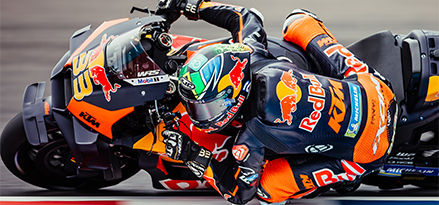 Motociclista Red Bull che percorre una curva su una moto Red Bull