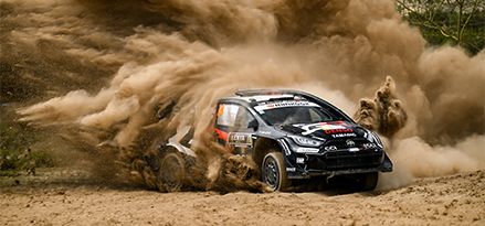 Auto da corsa Toyota in curva che solleva nuvole di polvere  