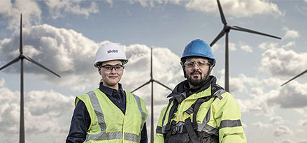 Dipendente Mobil e cliente davanti a turbine eoliche